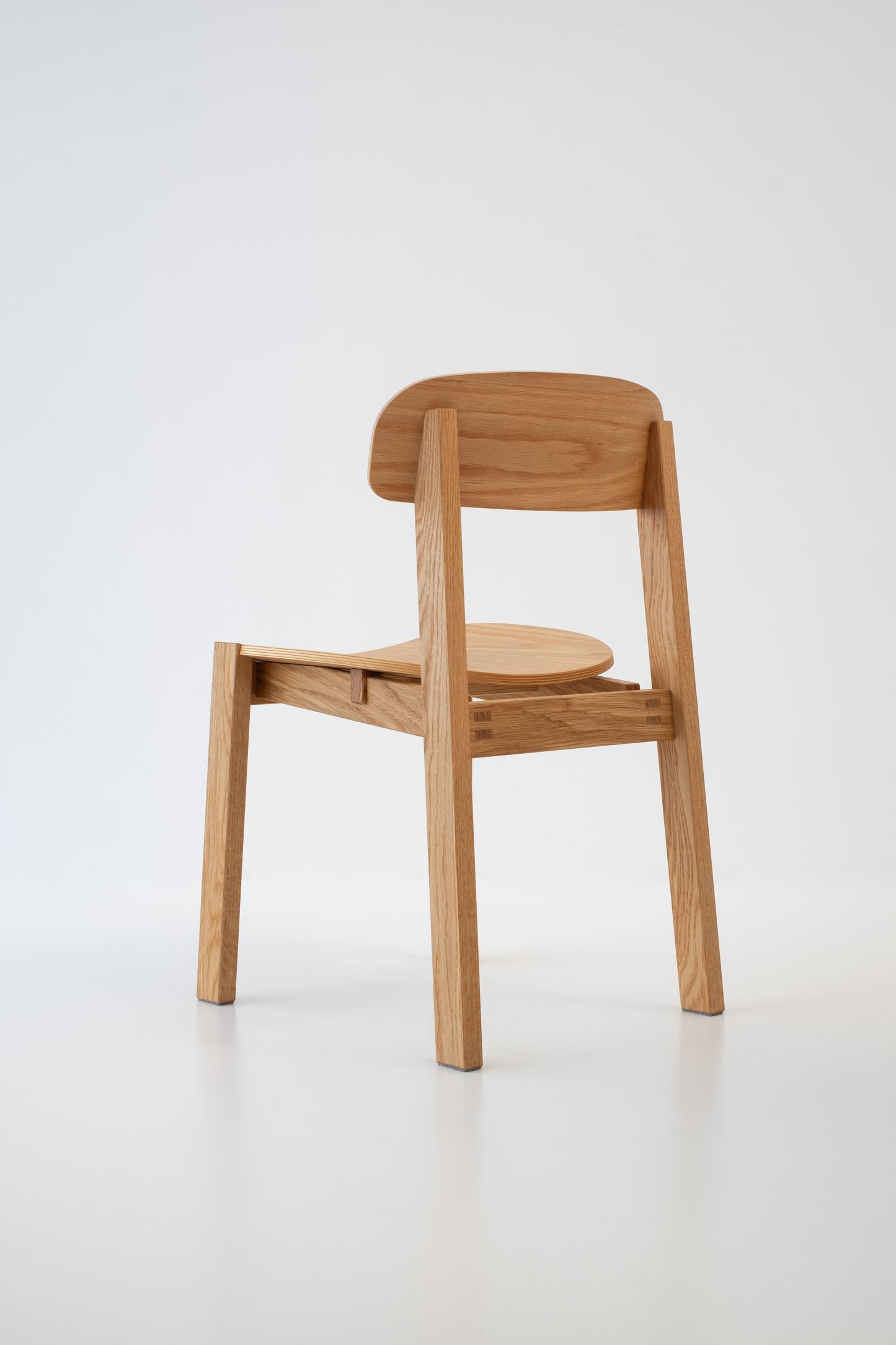 Siirto Chair from the back side view, highlighting the elegant craftsmanship and solid wood frame, perfect for home or restaurant.