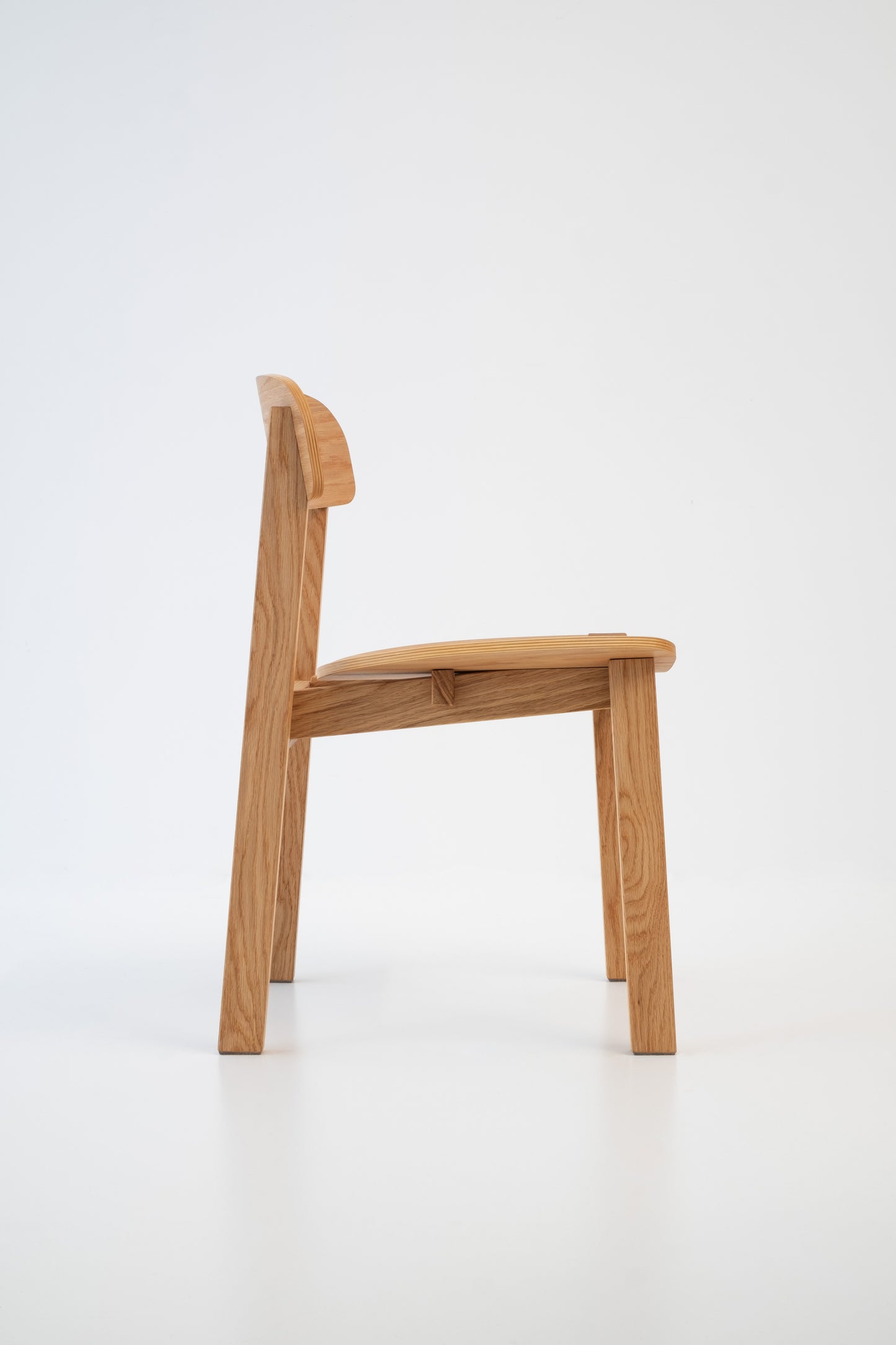 Siirto Chair from the right side view, showcasing its architectural Nordic design and elegant wood finish.
