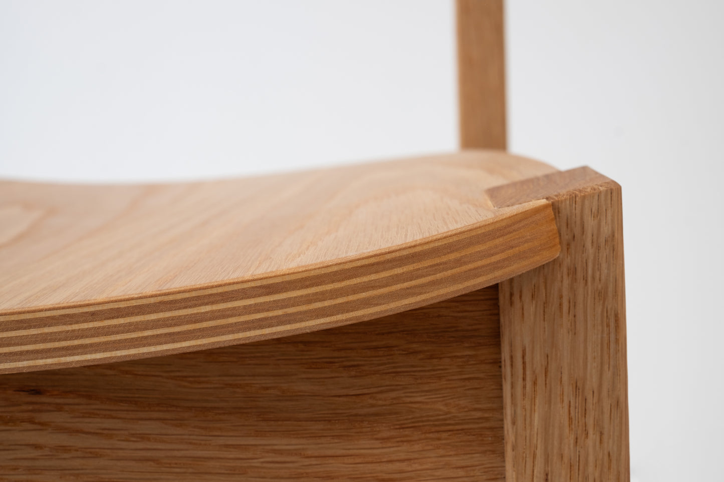 Close-up of Siirto Chair’s handcrafted veneer bending details on the seat, showcasing expert craftsmanship.