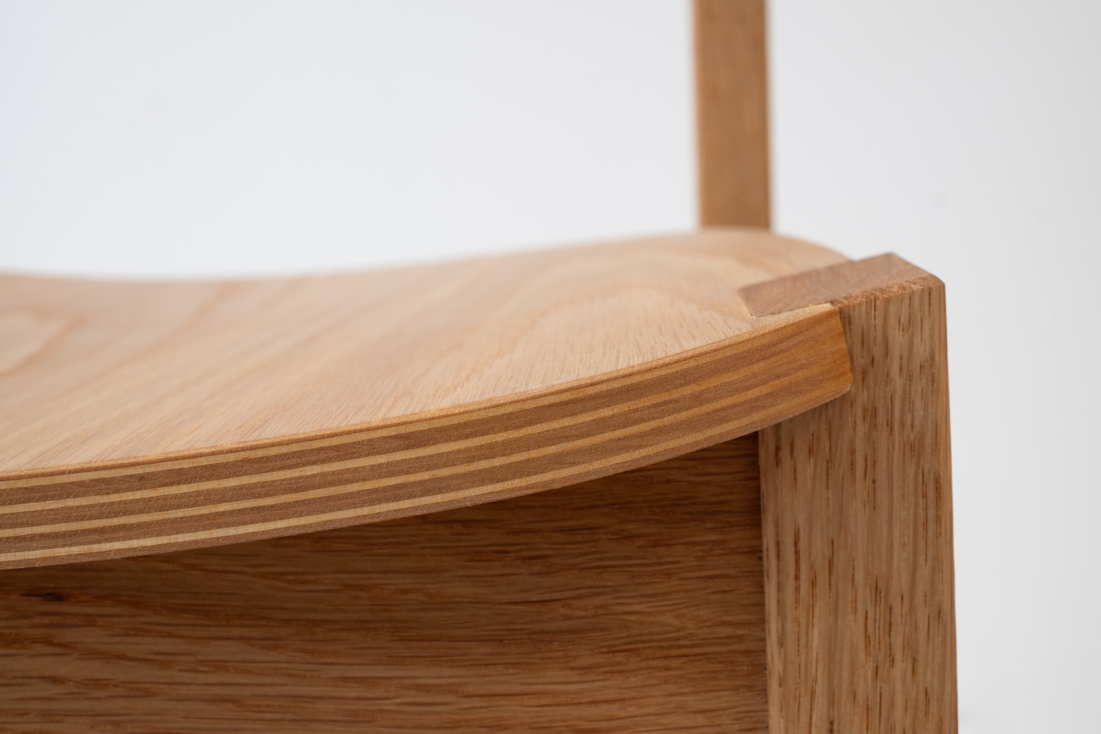 Close-up of Siirto Chair’s handcrafted veneer bending details on the seat, showcasing expert craftsmanship.