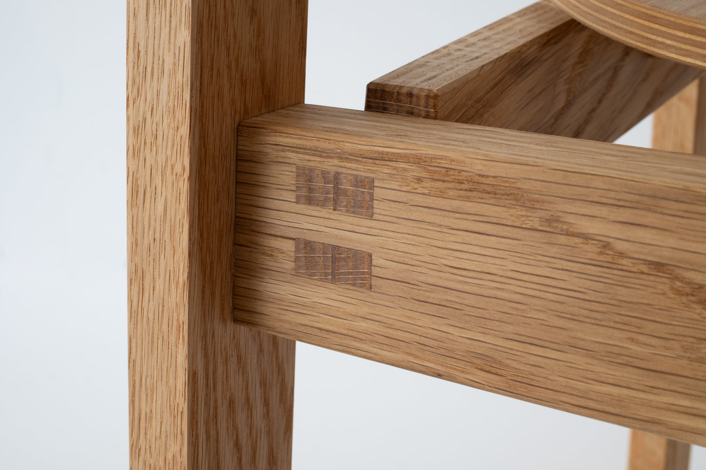 Close-up of the handcrafted joints and wood finish on the Siirto Chair, showcasing expert craftsmanship.