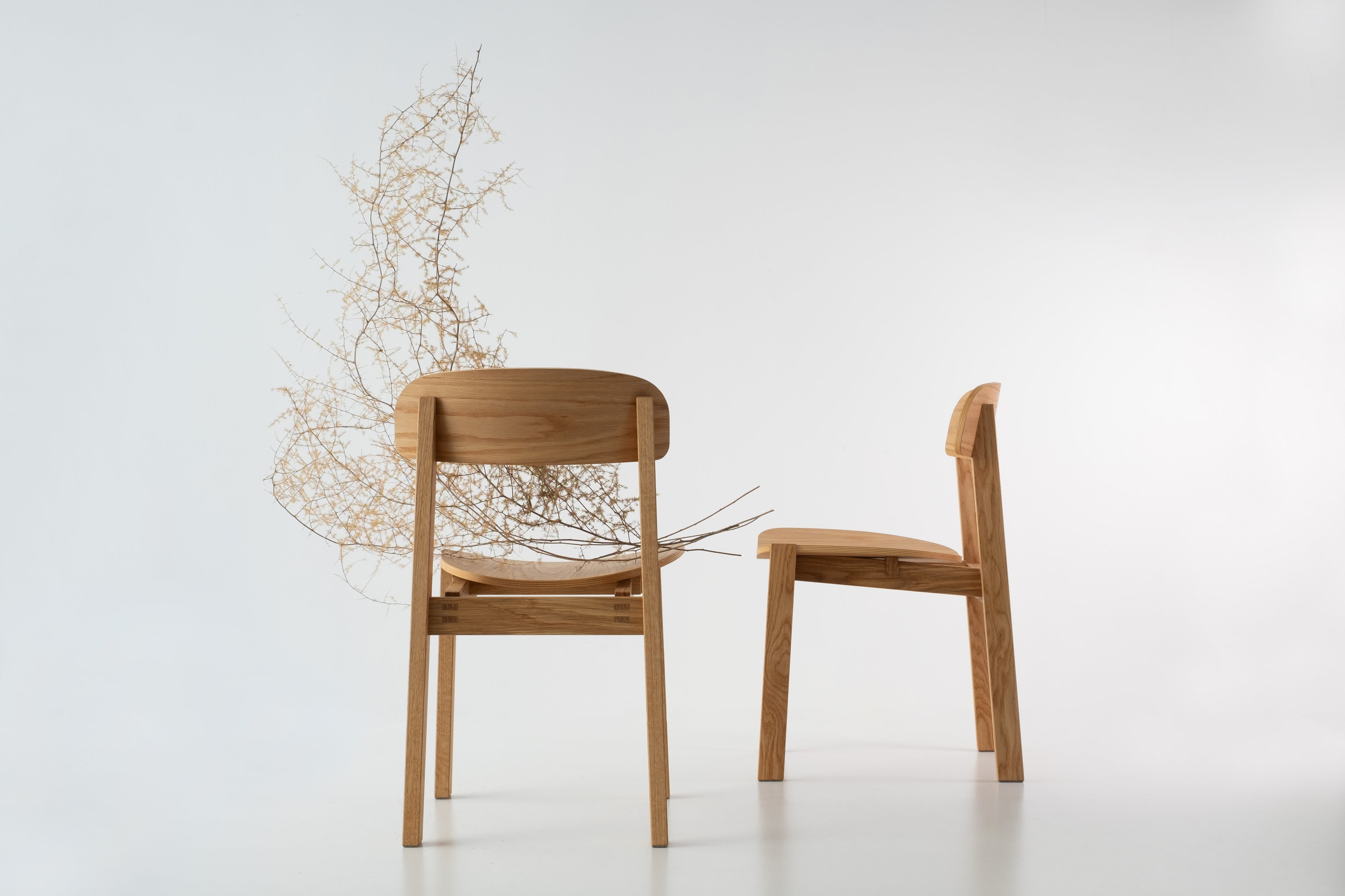 Siirto Chairs from the front and side view, bringing Nordic elegance and comfort to a modern dining space.