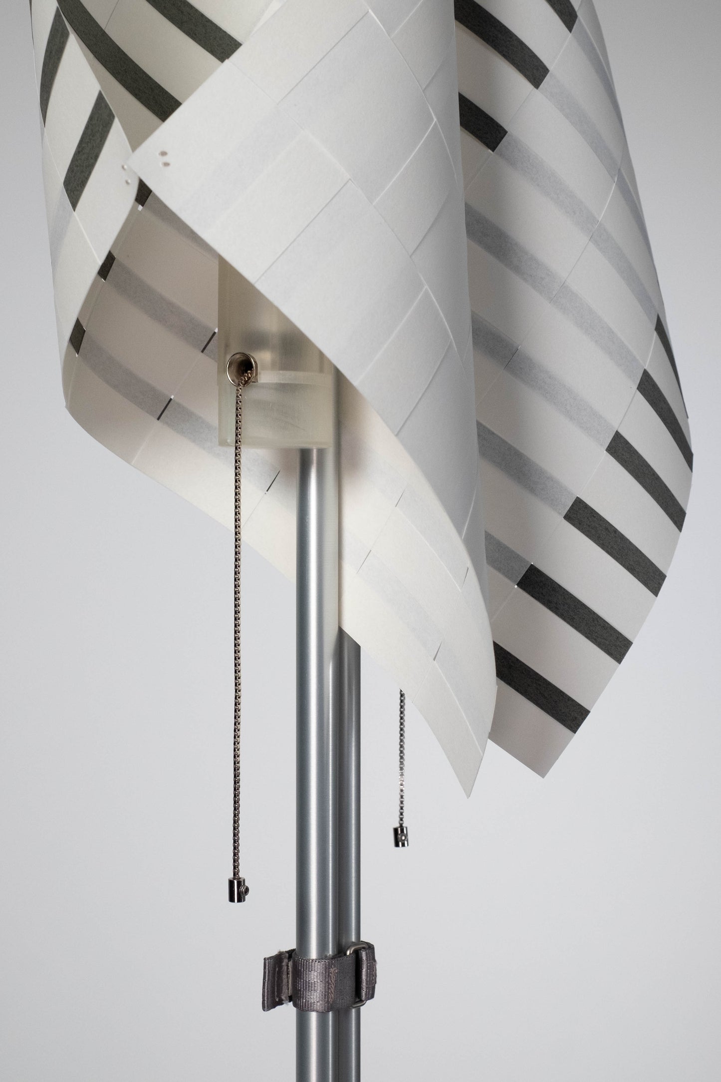 Close-up of TEX001 floor lamp details, highlighting the delicate pull chain switch, translucent lamp holder, and sculptural handwoven paper lampshade.