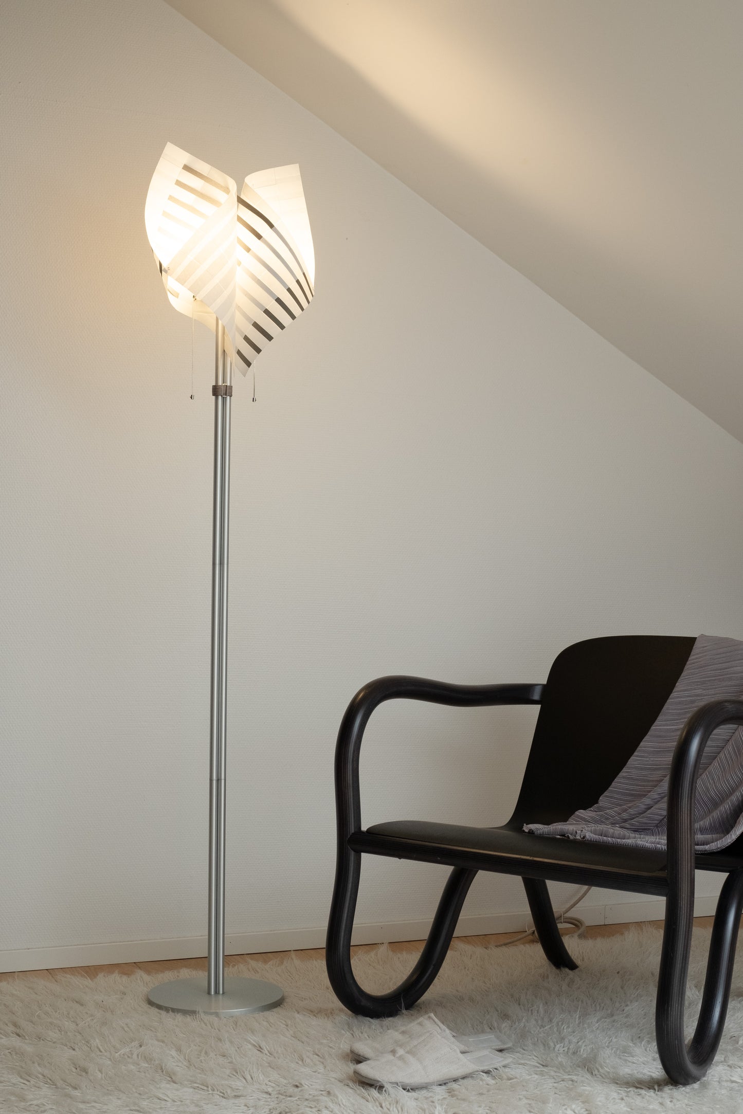 TEX001 floor lamp in a tranquil lounge corner, bathed in soft daylight, creating a calm and reflective atmosphere.