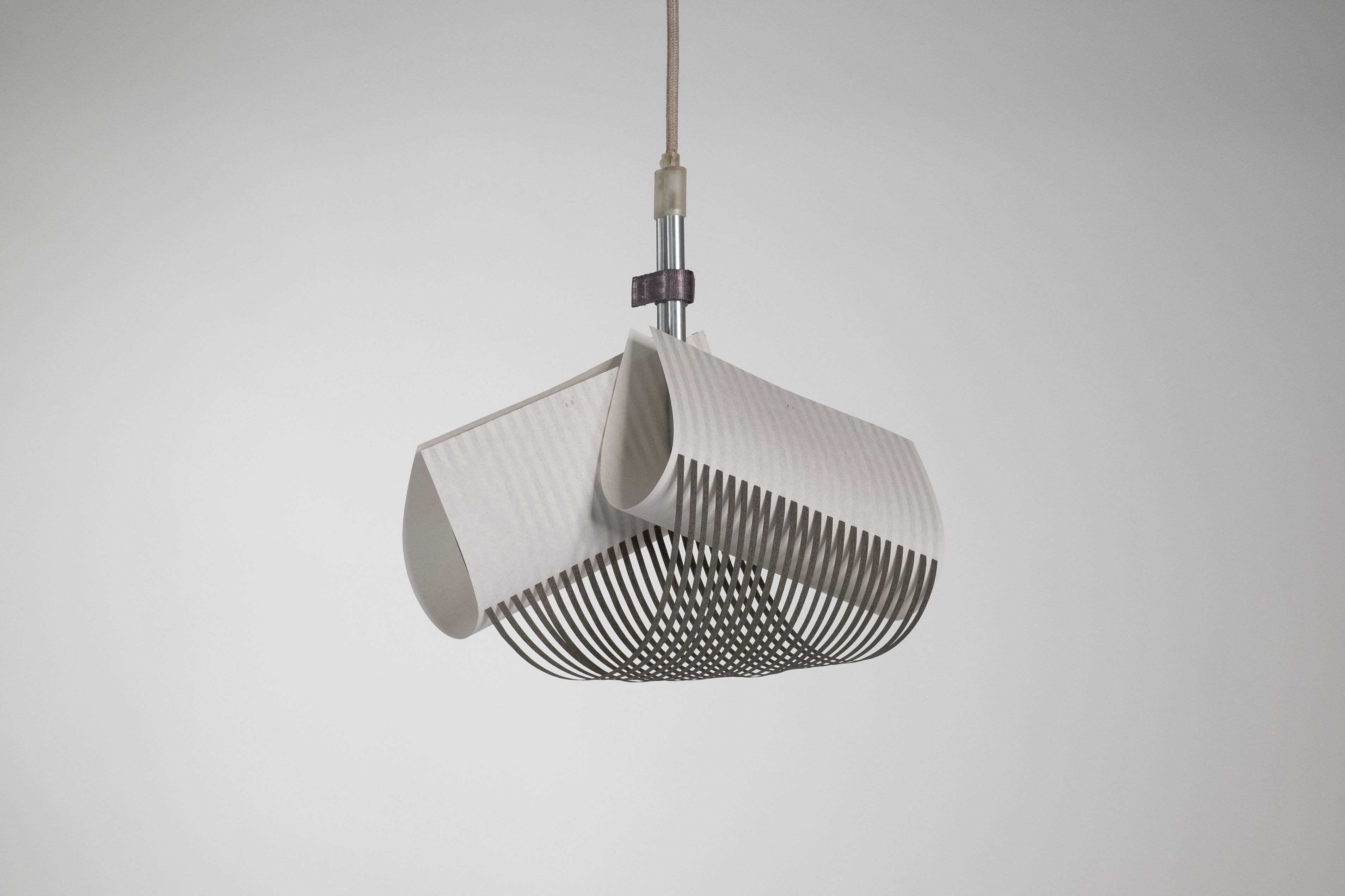 TEX003 pendant lamp with its light off, highlighting the structured, geometric surface of the handwoven paper lampshade and the refined craftsmanship.