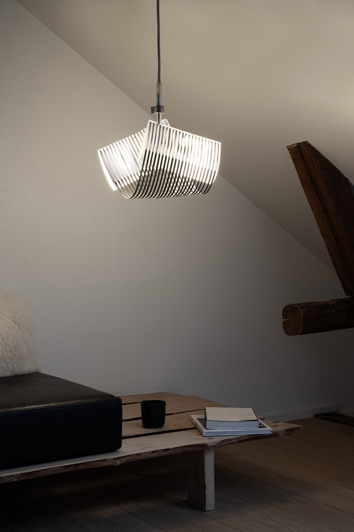 TEX003 pendant lamp in a modern lounge corner with a bench sofa, enhancing the space with its sophisticated geometric design and creating a tranquil, refined atmosphere.