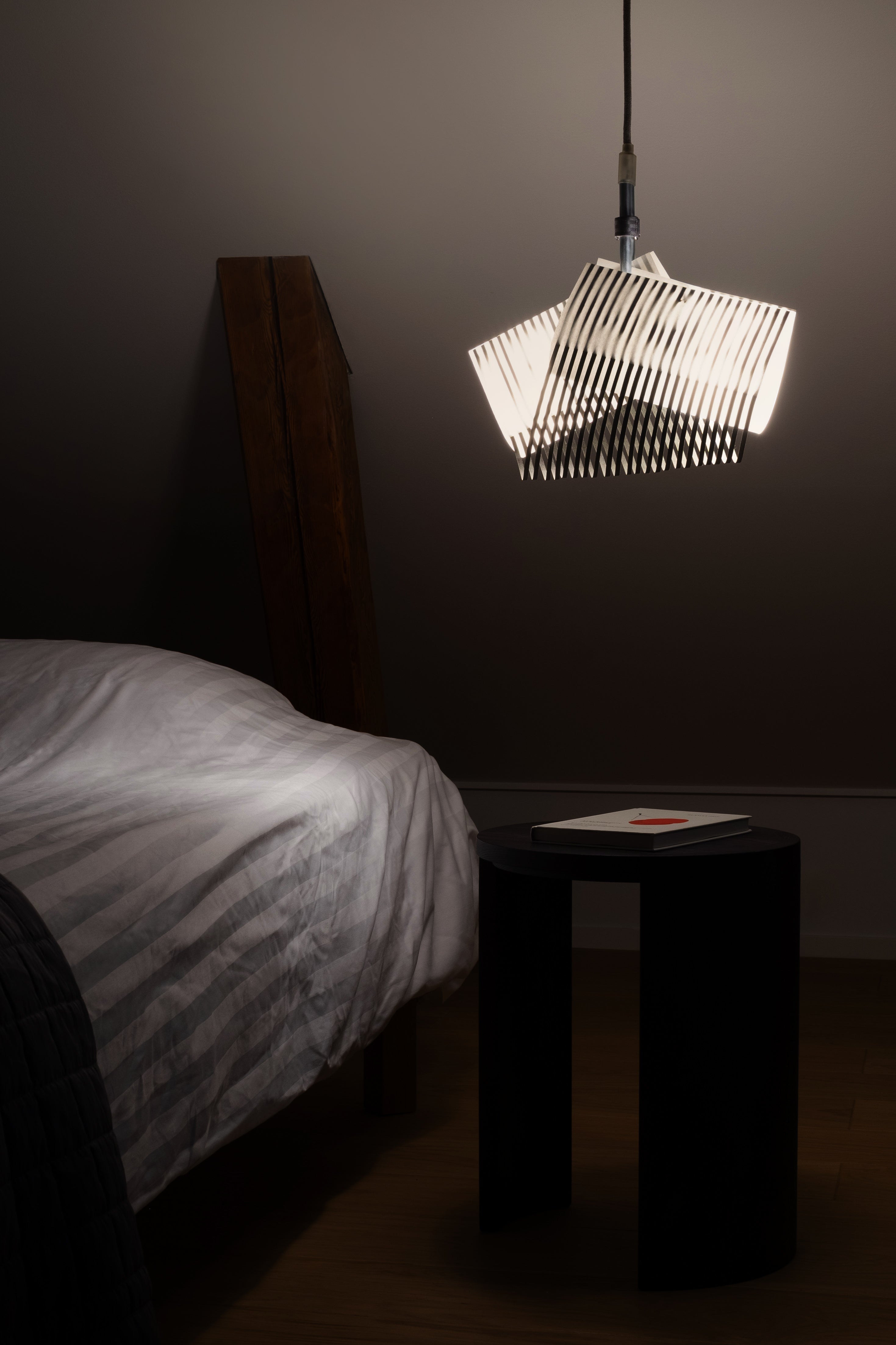 TEX003 pendant lamp in a serene bedroom setting, placed by the bedside, enhancing the space with its geometric design and sophisticated, modern aesthetics.