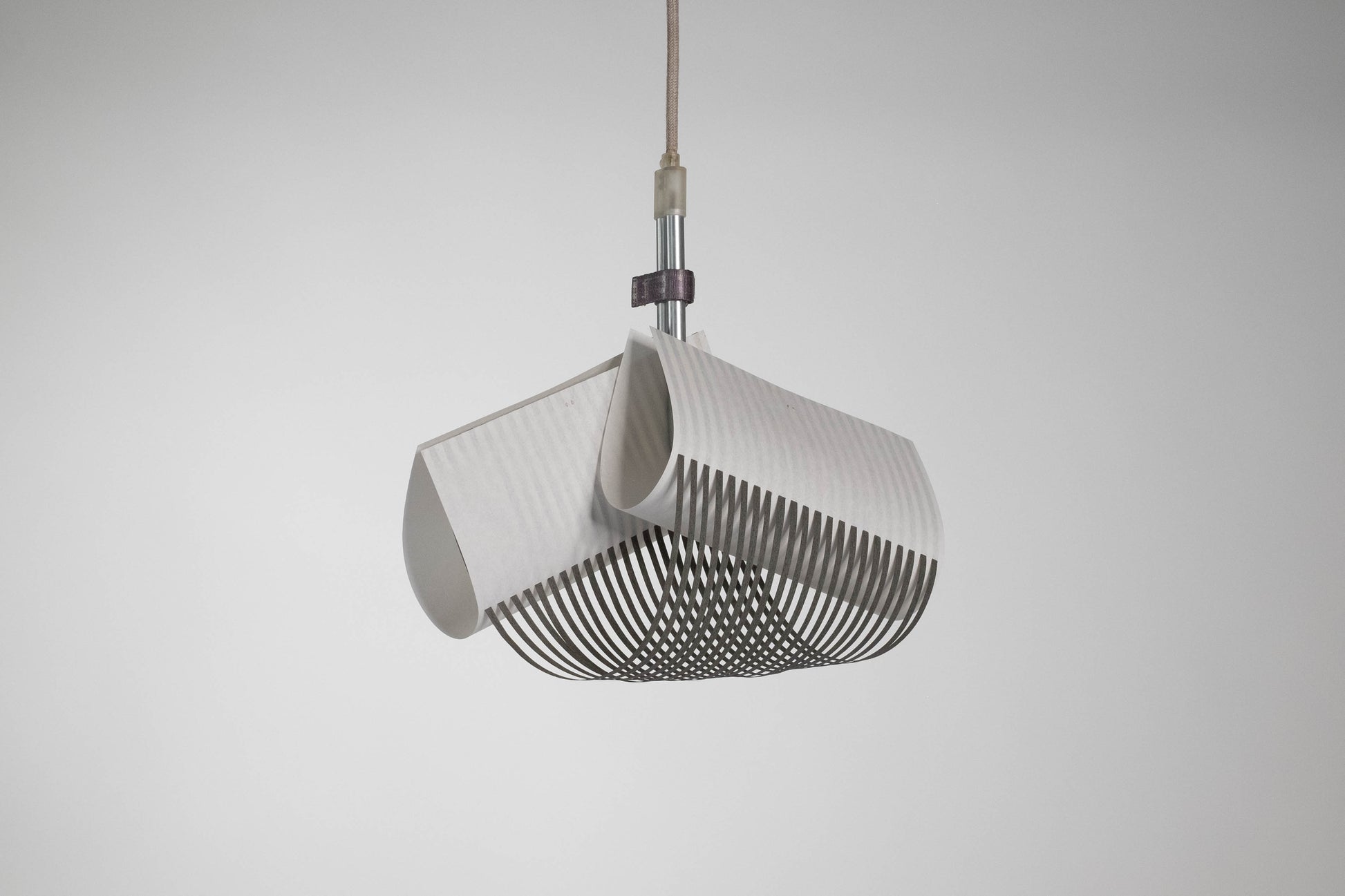 TEX003 pendant lamp with its light off, highlighting the structured, geometric surface of the handwoven paper lampshade and the refined craftsmanship.