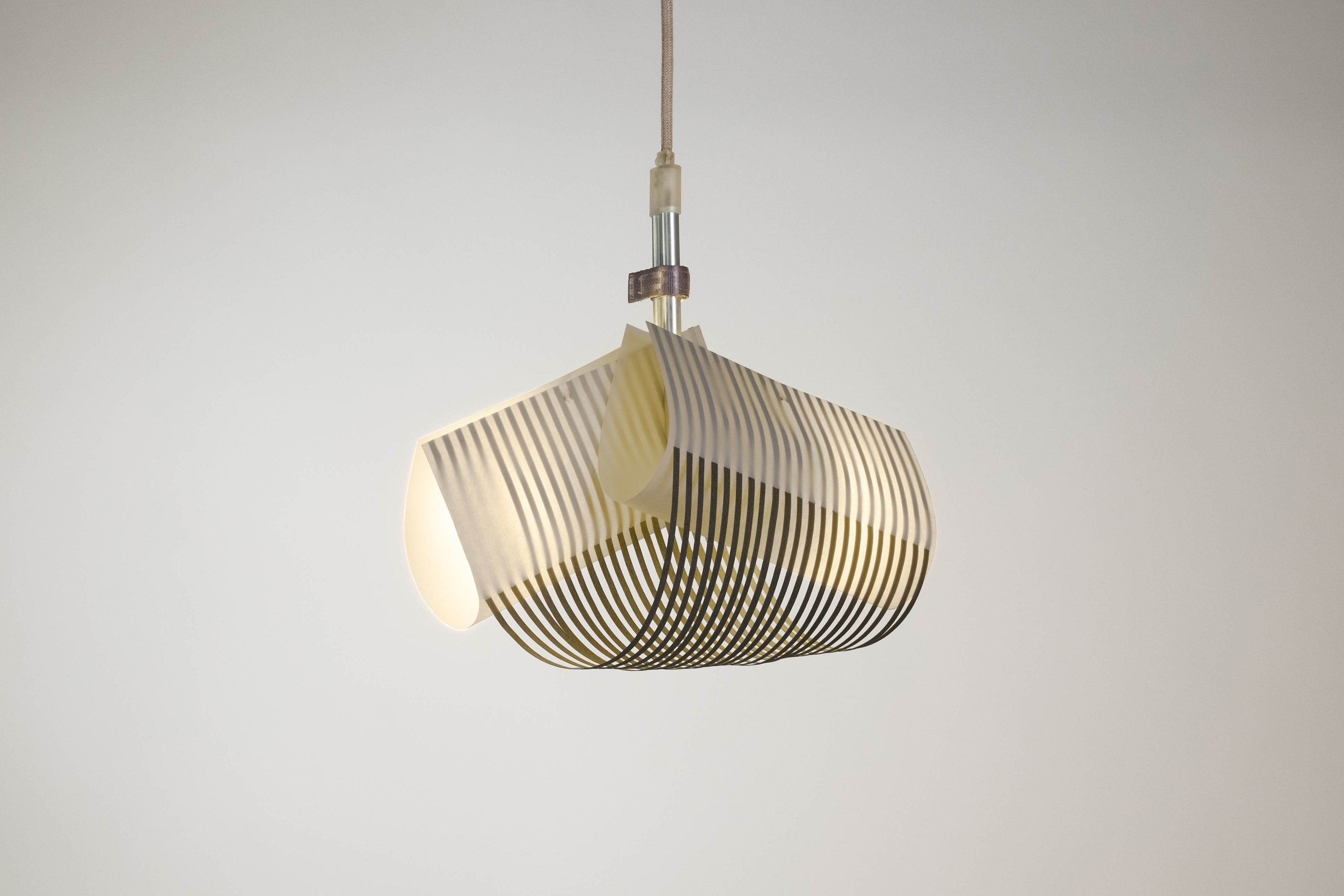 TEX003 pendant lamp illuminated, showcasing its intricate, geometric design with neatly aligned stripes, creating a sophisticated and architectural form.